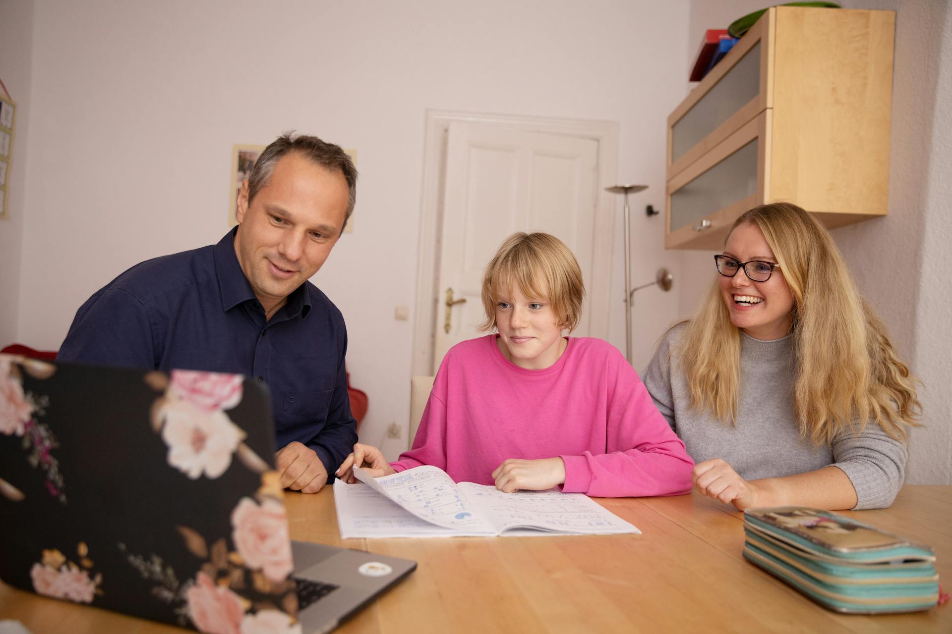 Parents helping their child on her homework